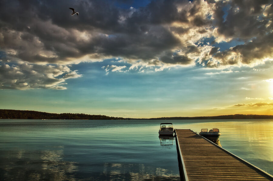 Motor boats moored on a jetty on Lake Macquarie, Australia at sunset