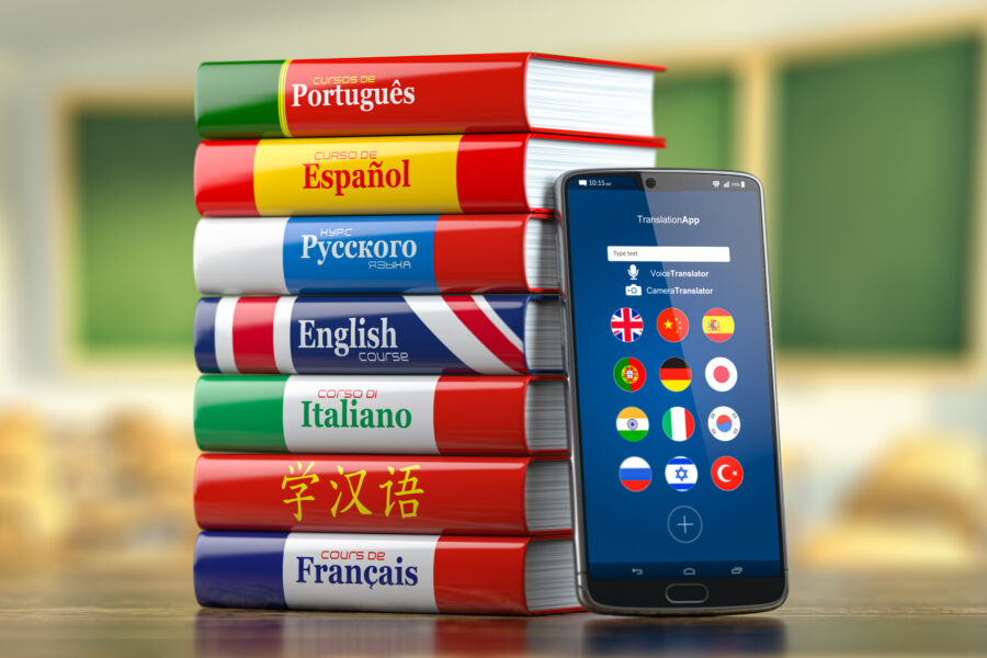 Smartphone alongside language course books, representing the concept of learning languages online