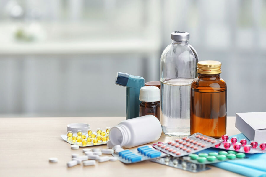 Different medicines and pills on wooden table