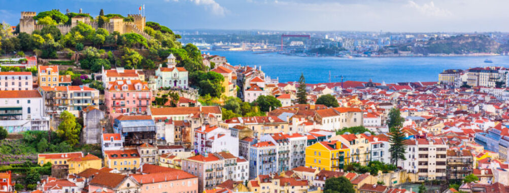 The skyline of Lisbon, Portugal, featuring a blend of traditional and contemporary structures under a bright sky