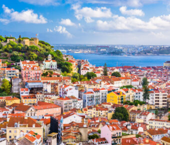 The skyline of Lisbon, Portugal, featuring a blend of traditional and contemporary structures under a bright sky