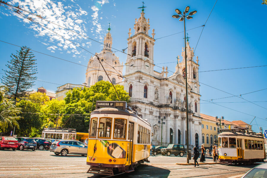 The iconic yellow tram 28 makes its way through Lisbon's scenic streets, a symbol of the city's rich culture and history