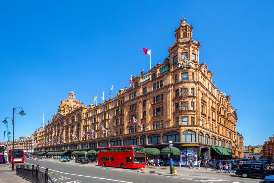 Lively London street scene featuring the renowned Harrods department store, surrounded by shoppers and historic architecture