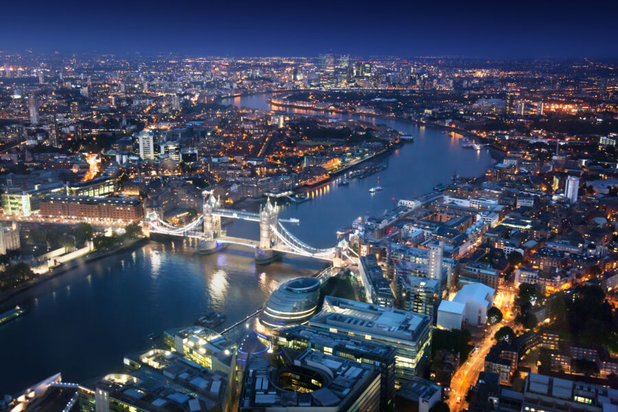 Scenic night view of London, displaying urban structures with the majestic Tower Bridge lit up in the evening sky