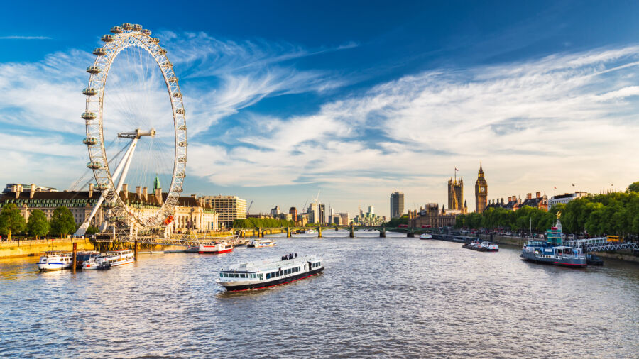 The iconic Westminster Parliament building alongside the serene River Thames in London, showcasing historic architecture