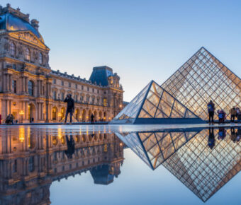 View of famous Louvre Museum with Louvre Pyramid at evening