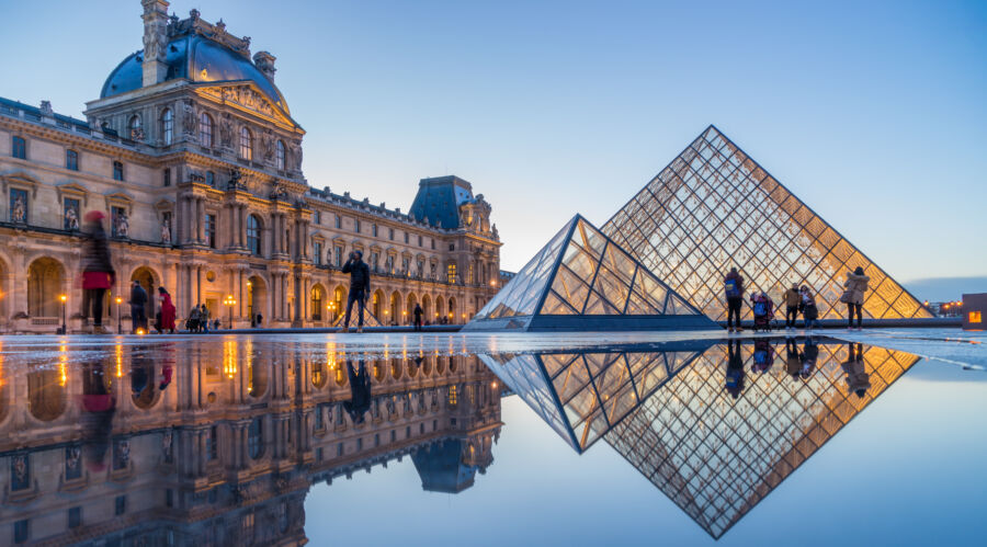 View of famous Louvre Museum with Louvre Pyramid at evening