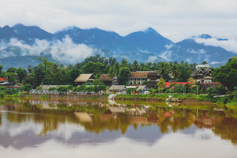 Scenic view of traditional architecture along the riverbank in Luang Prabang, Laos, reflecting the city's unique charm