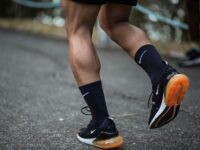 Man running wearing black running shoes and socks