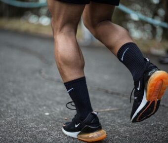 Man running wearing black running shoes and socks