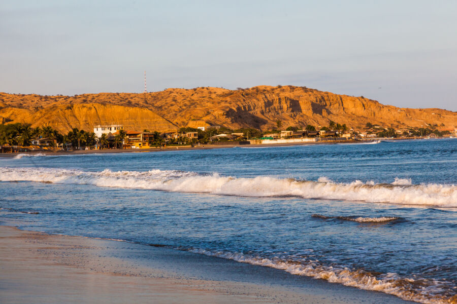 Panoramic view of a vibrant sunset over Mancora Beach, Peru, with colorful skies reflecting on the tranquil ocean waters