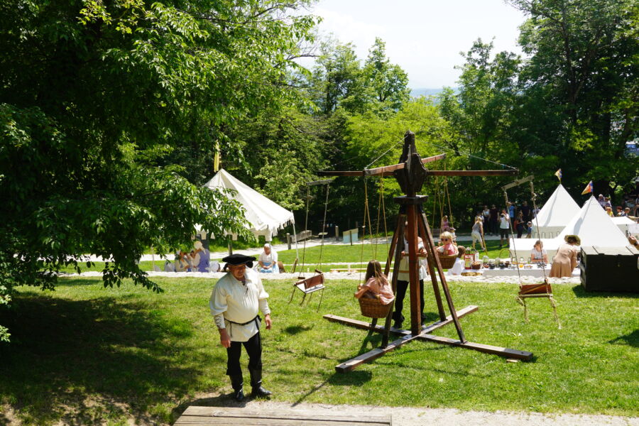 Hand-operated carousel at the medieval festival in Bled, Slovenia, featuring colorful decorations and joyful participants