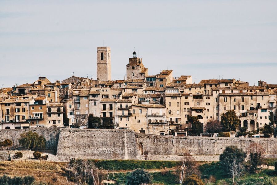 Charming historic hillside town with terracotta roofs and a prominent clock tower.