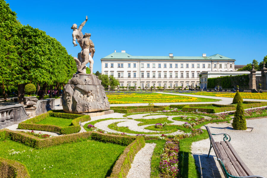 Beautiful Mirabell Palace gardens in Salzburg, showcasing vibrant flowers and elegant pathways under a clear blue sky