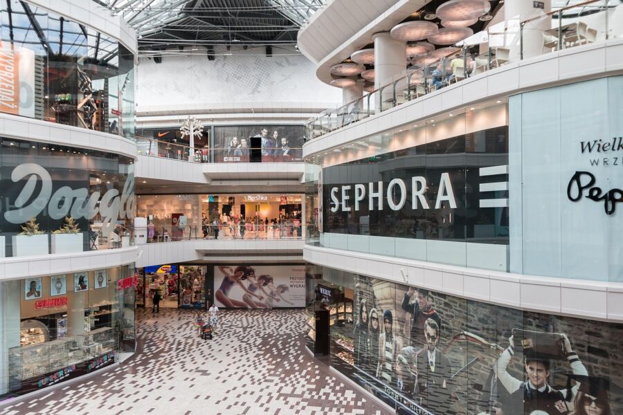 Munich shopping mall interior with luxury stores, natural lighting, and vibrant atmosphere.