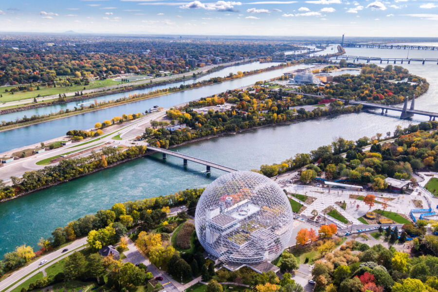 Aerial view of Montreal showcasing its vibrant cityscape, with buildings, parks, and the St. Lawrence River in the background