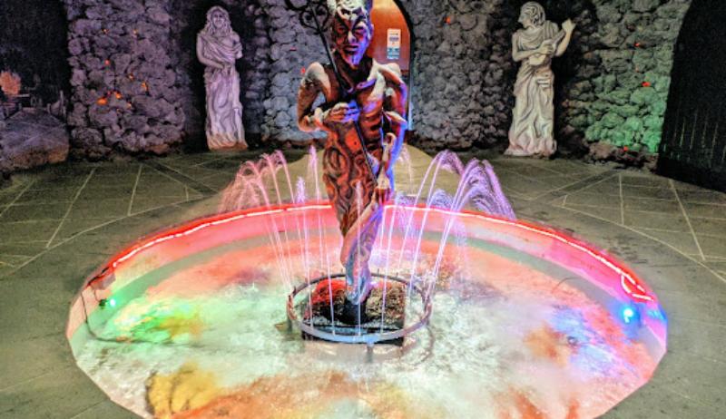 Colorful indoor fountain with statue and mystical stone