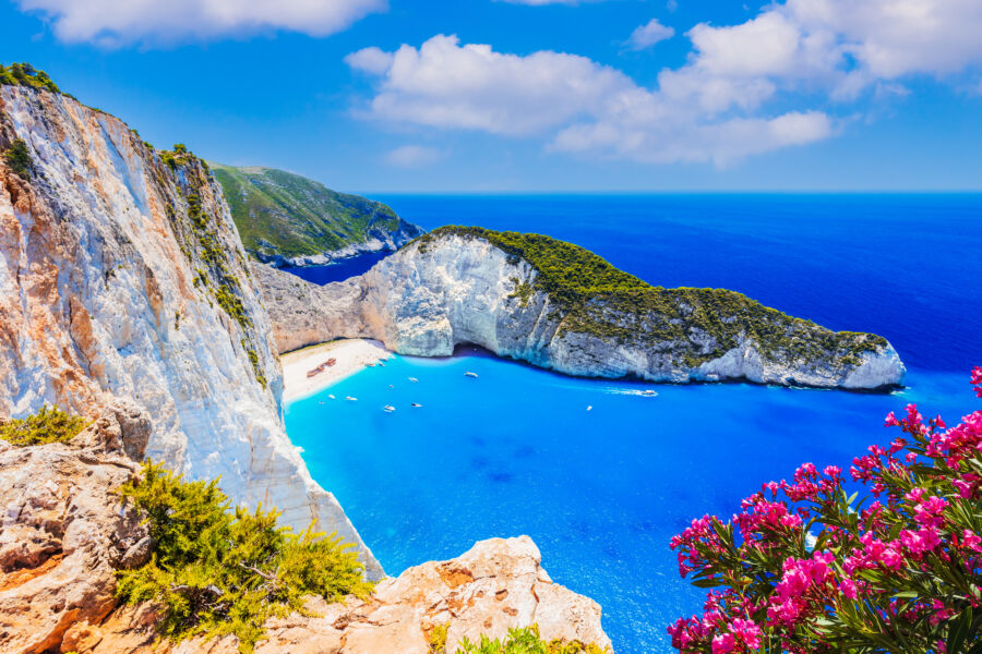 Picturesque view of Navagio Beach on Zakynthos island, showcasing a shipwreck nestled among dramatic cliffs and clear waters