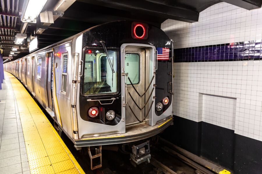 Interior view of a New York subway wagon, featuring seated passengers and the distinctive metropolitan transit atmosphere