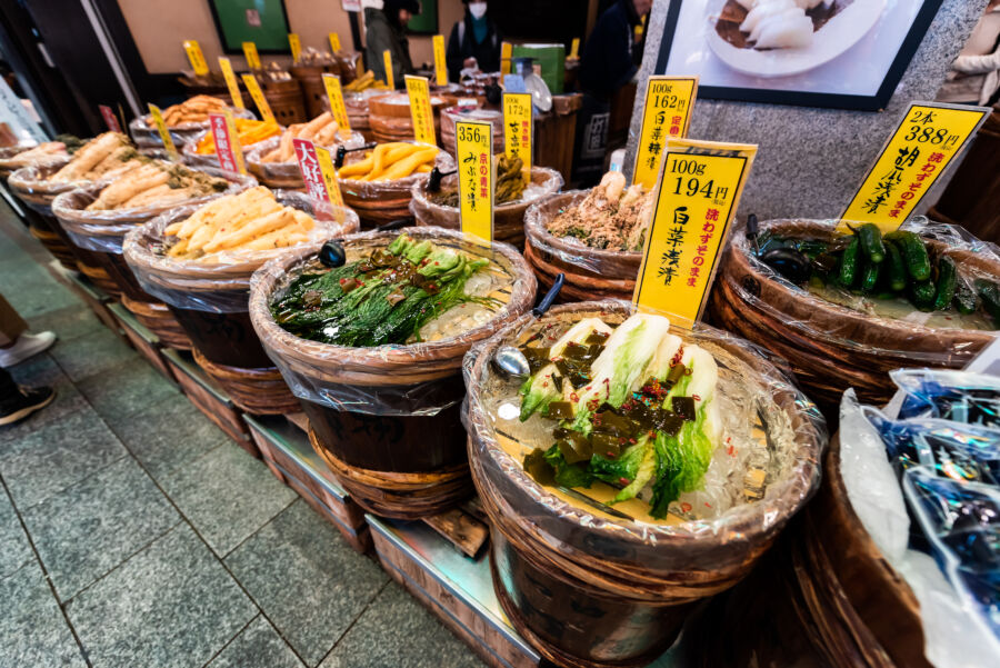 Vibrant display of pickled vegetable containers at Nishiki Market, Kyoto, Japan