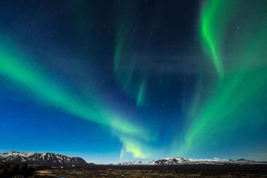 The vibrant aurora borealis dances over Thingvellir National Park, showcasing Iceland's natural beauty