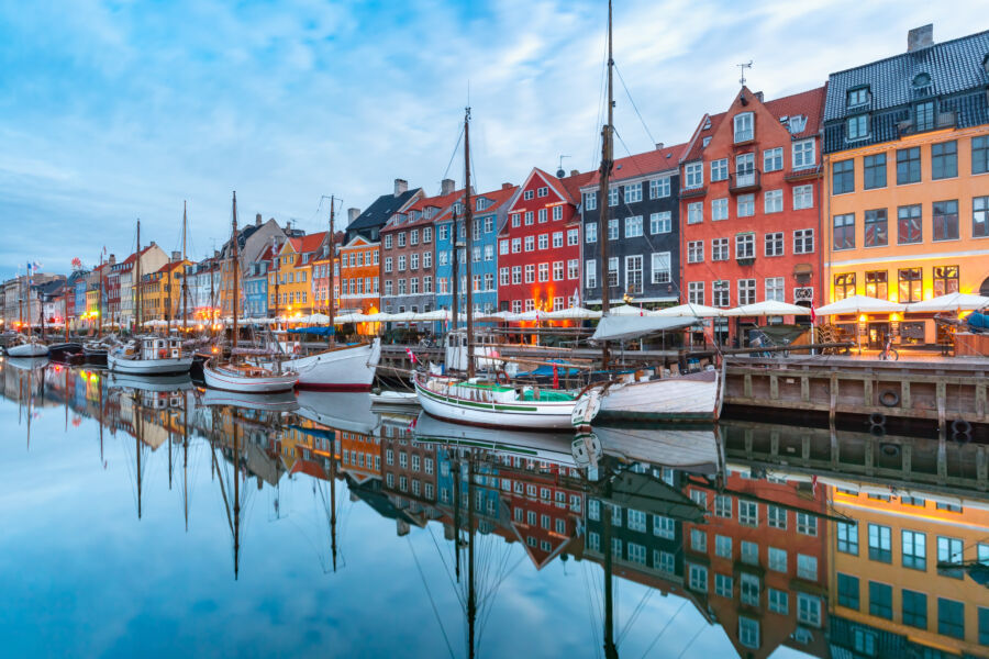 Picturesque view of Nyhavn in Copenhagen, featuring colorful buildings along the waterfront and boats docked in the canal