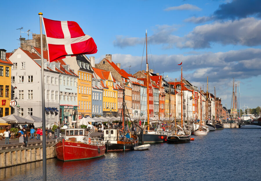 Sunny summer day in Nyhavn, Copenhagen, featuring lively waterfront scenes and charming, colorful architecture