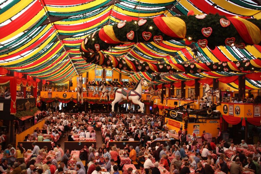 Festive Oktoberfest celebration with colorful decorations and joyful patrons enjoying food and drinks.