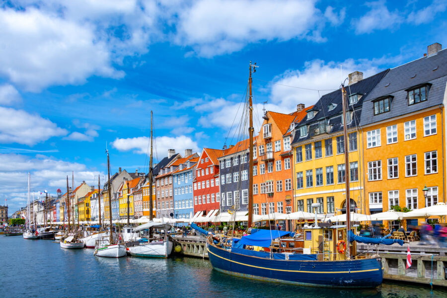 Colorful buildings and boats line Nyhavn pier, highlighting the picturesque scenery of Copenhagen's historic Old Town