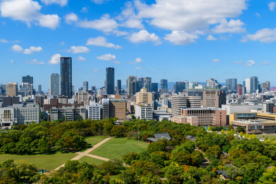 Panoramic view of Osaka city from the castle, featuring buildings against a bright blue sky