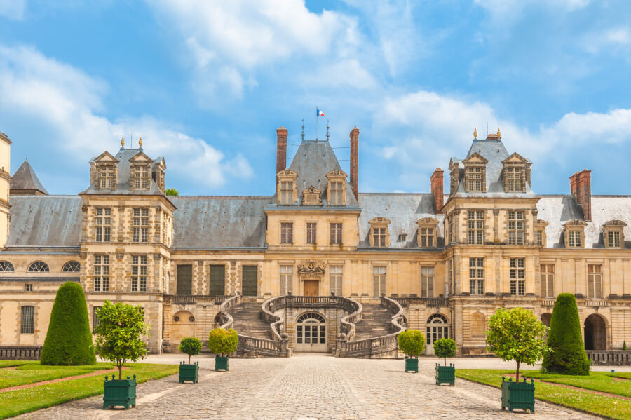 The stunning Palace of Fontainebleau, a historic royal residence near Paris, showcasing beautiful architecture and lush gardens. 