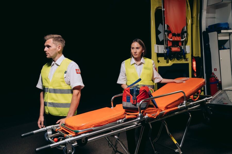 Munich Paramedics in reflective vests with stretcher and ambulance, ready for emergency response.