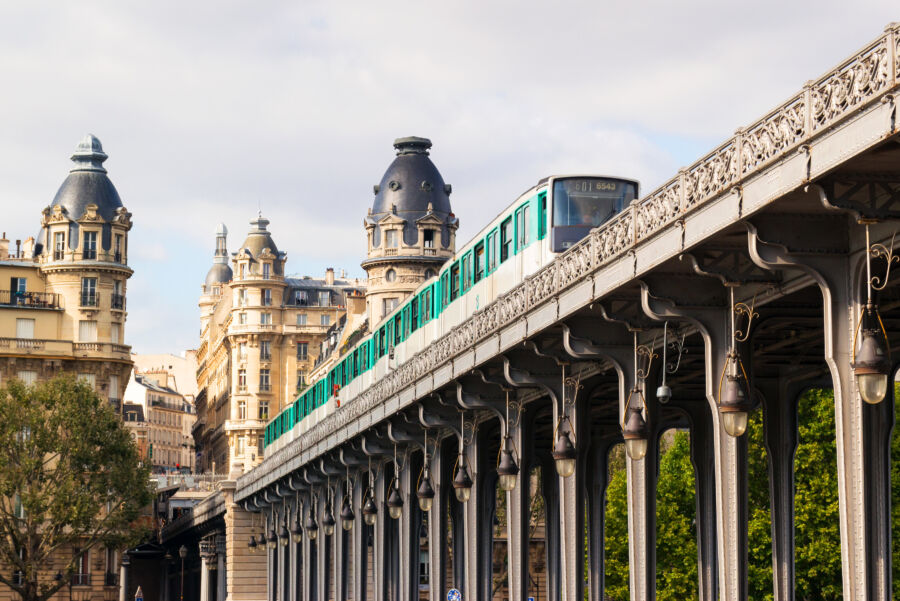 Close-up of a metro train running high above buildings in a summer cityscape of Paris, France