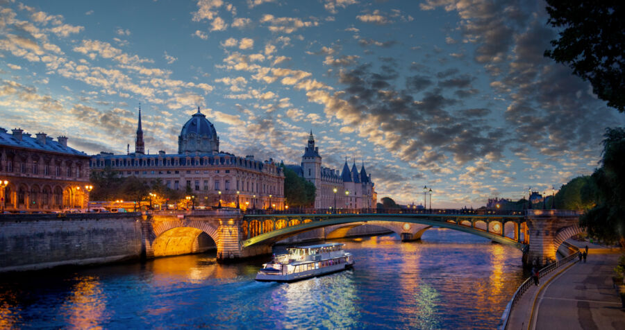 Nighttime in Paris, showcasing the river adorned with shimmering lights, creating a picturesque urban landscape