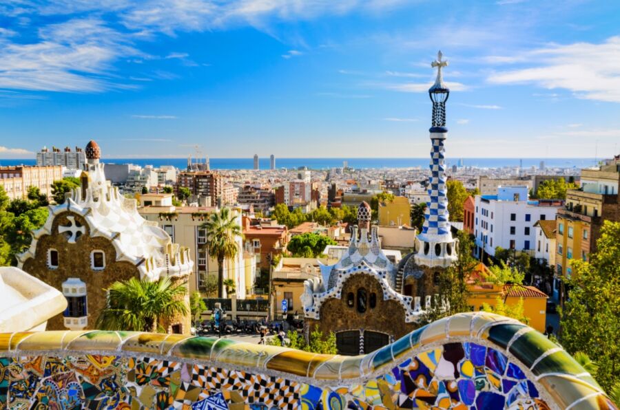 Picturesque scene of Park Guell in Barcelona, highlighting its iconic mosaics and imaginative architecture set in a lush park