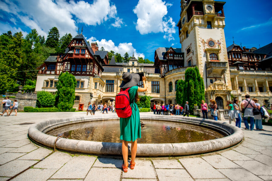 Female tourists exploring the stunning architecture of Peleș Castle in Sinaia, Romania