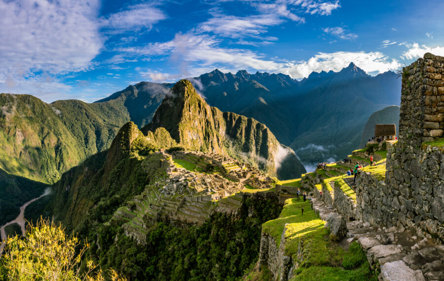 Panoramic view of a vibrant sunset over Machu Picchu, showcasing the ancient Inca site in Peru's breathtaking landscape