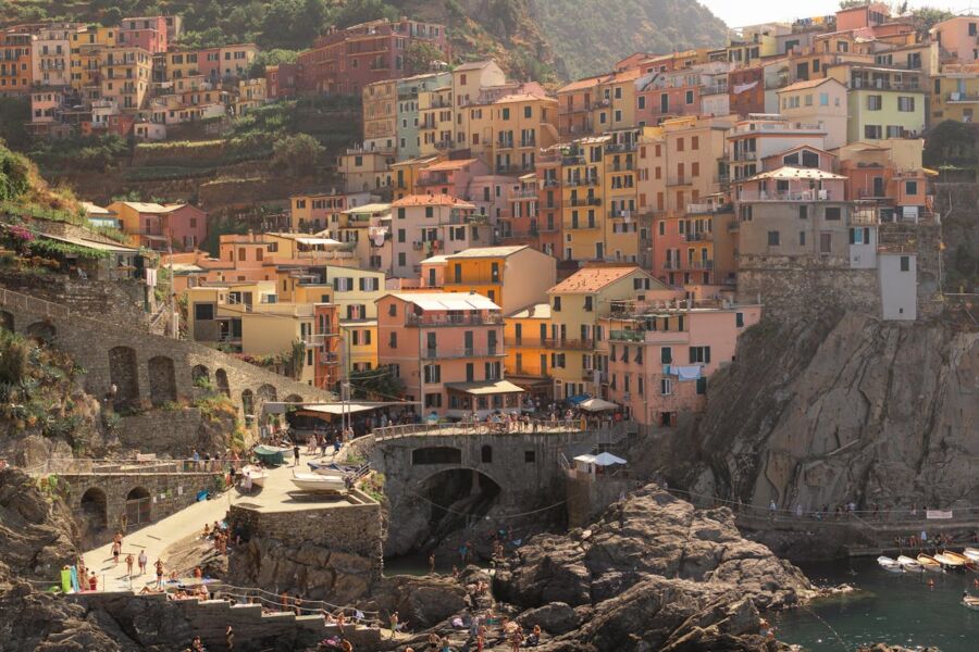 Vibrant Italian coastal village with pastel buildings, terraced vineyards, and picturesque shoreline.