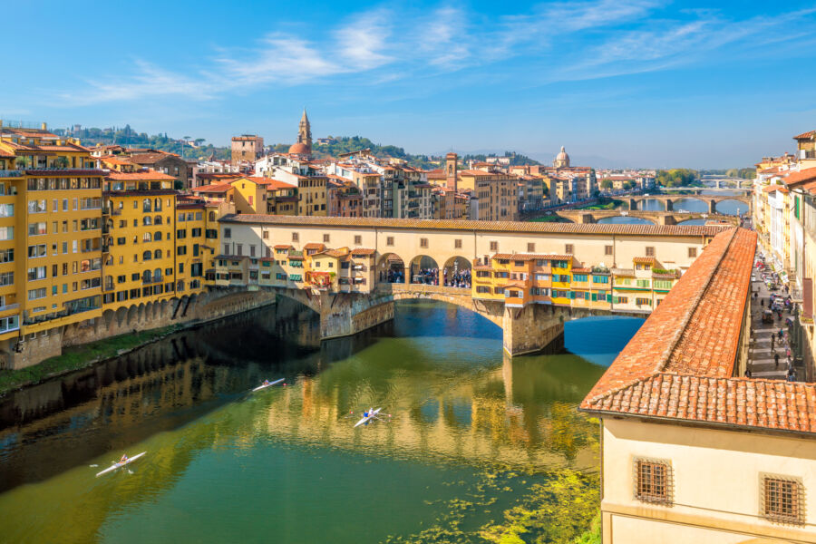 The Ponte Vecchio bridge spans the Arno River in Florence, showcasing its historic architecture and vibrant atmosphere