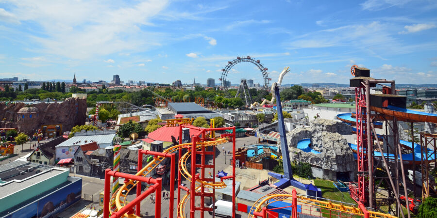 Panoramic view of Prater Amusement Park in Vienna, Austria, showcasing rides and attractions against a clear blue sky