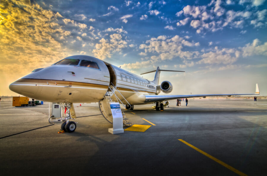 Private aircraft with open doors, showcasing a stunning sunset view in the background