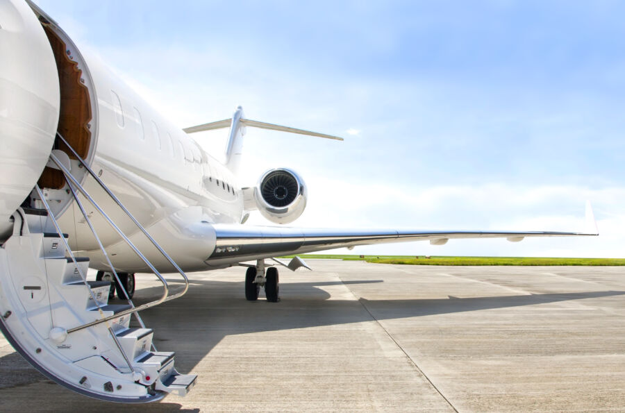 Stairs leading to a private jet door, featuring a jet engine mounted beside the entrance