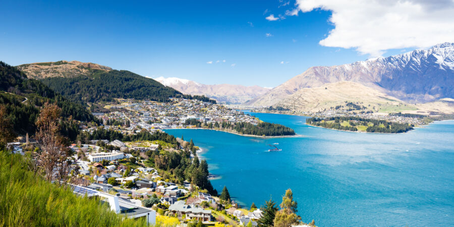 Stunning view of Queenstown, New Zealand, bathed in sunlight, showcasing its beautiful landscapes and vibrant atmosphere