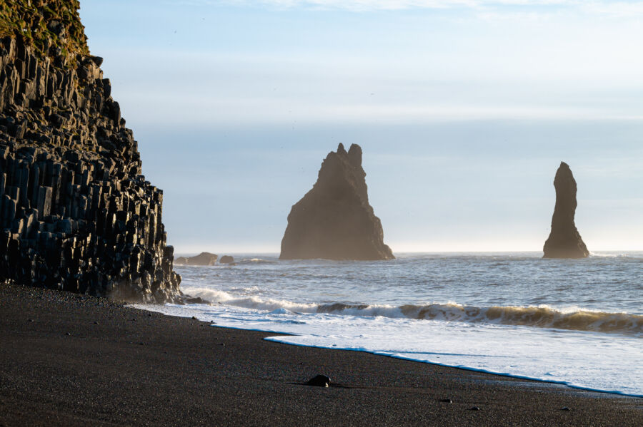 Scenic view of Reynisfjara black sand beach in Iceland, with towering ocean cliffs and unique geological formations