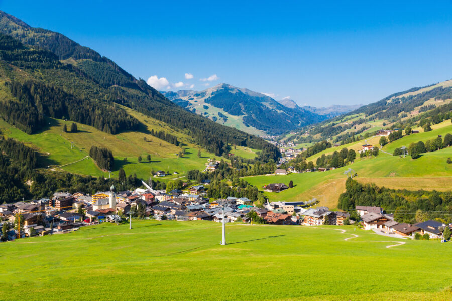 Summer view of Saalbach village nestled in the Austrian Alps, showcasing lush greenery and charming alpine architecture