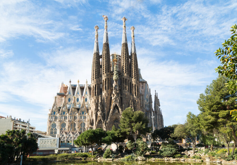 The iconic Sagrada Familia stands prominently in Barcelona, surrounded by a stunning skyline and clear blue skies.