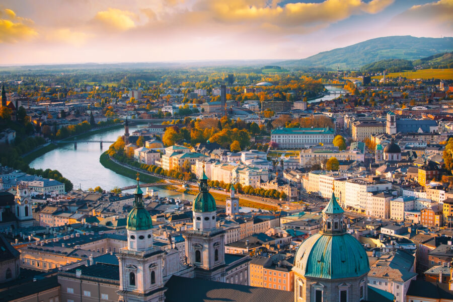 Panoramic aerial shot of Salzburg in autumn, featuring vibrant fall colors and the Salzach River flowing through the city