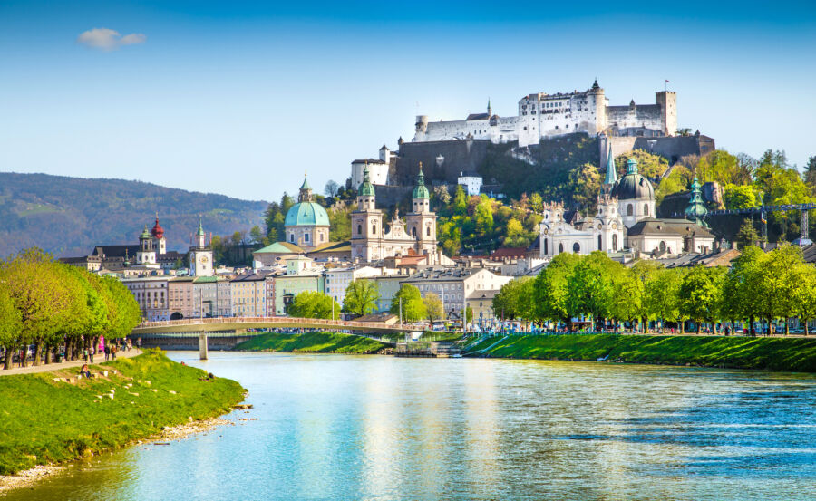 Scenic view of Salzburg's skyline in spring, featuring the Salzach River and vibrant greenery