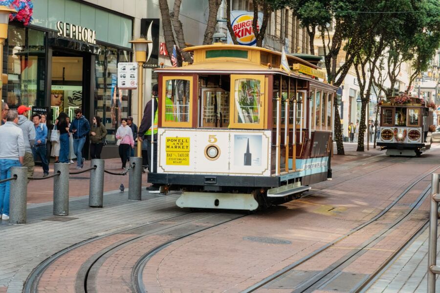 San Francisco cable cars on bustling city street near Powell Market and shopping district.