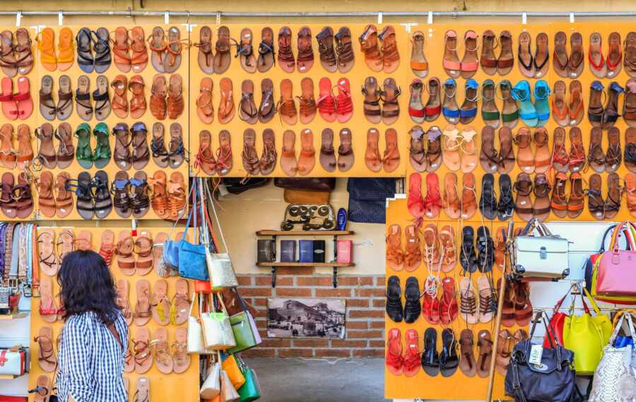 Leather sandals neatly displayed on a wall at the San Lorenzo market in Florence, Italy, representing traditional Italian footwear.